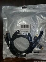 Clear plastic resealable bag containing coiled black HDMI cables and adapters, product label visible.