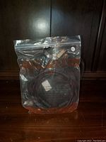 Full view of new VGA cable sealed in plastic bag on wooden surface.
