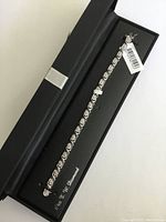 Sterling silver diamond tennis bracelet in black gift box, partially open showing interior