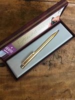 Gold-tone Sheaffer pen inside original maroon textured box with gray insert and visible Lifetime Guarantee card