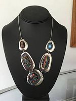 Front view of vintage silver plated necklace on black display bust showing five large pendants with colorful bead inlays.