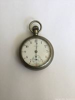 Front view of the vintage Elgin pocket watch showing white dial with black numerals and subdial at 6 o'clock.