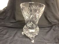 Photo of clear pinwheel cut crystal footed vase with three small legs, showing overall shape and pattern