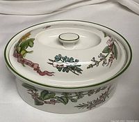 Top and side view of Royal Worcester porcelain casserole dish with lid in Country Kitchen pattern, showing botanical herb illustrations and green rim details.