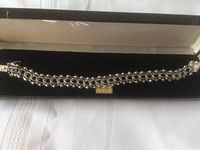 Sterling silver bracelet displayed inside black jewelry box with gold "Sterling Silver" label.