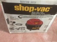 Cardboard box with Shop-Vac branding and specifications describing the wet/dry vacuum model.