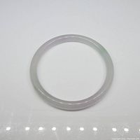 Top-down view of the round jade bangle bracelet showing its translucency and coloration.