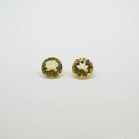 Front view of two round citrine gemstones on a white background.