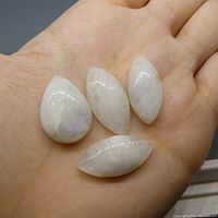 Four polished pear and marquise cabochon rainbow moonstones in hand showing size and shape variety