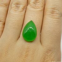 Jadeite cabochon placed on fingertip for scale