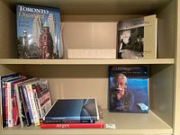 Bookshelves with assorted photography-related books, a decorative beige box, and various books on photographic techniques and digital editing