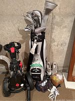 Overview of Callaway golf club set in bag with headcovers, folding push cart, women’s golf shoes, golf glove, bag of balls and tees