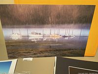 Photo shows misty dock with several boats lined up on calm water, part of the photography collection.
