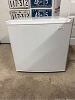 Closed white Sanyo mini fridge showing the front door and logo.