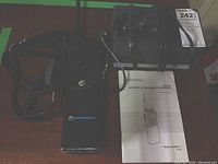 Motorola transceiver, charging dock, and owner's manual on wood surface