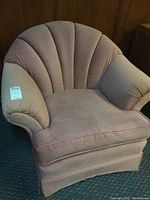 Front and angled views of pink velvet armchair with shell-back upholstery and cushioned arms, showing overall condition and chair silhouette.