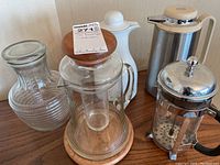 All items displayed on wooden table showing the complete set of drink carafes and press.
