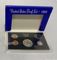 1969 United States Proof Set in blue cardboard sleeve and clear acrylic display case showing all five coins.