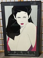 Front of the framed print featuring the Nagel stylized portrait of a woman labeled 'NAGEL THE BOOK' with the print covering most of the frame.