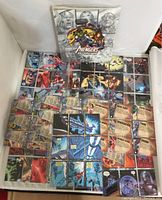 Open binder on display with 142 cards arranged neatly showing multiple cards forming composite images and individual cards depicting character artwork and comic panels.