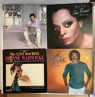 Four vinyl records and their cover sleeves, showing front artwork and artist portraits.