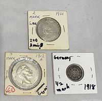 Top view showing front side of three German Empire coins each in labeled protective covers: 2 Mark 1901, 3 Mark 1912, 1/2 Mark 1918