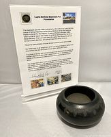 Pot with provenance display behind it showing detailed background information and photos.