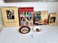Four Queen Elizabeth commemorative books and two trinket dishes displayed on a textured white surface.