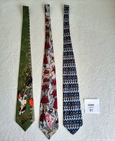 Three cartoon character neckties laid flat on a white textured fabric background. Left to right: green Droopy the Dog tie, beige Pink Panther tie, blue Mickey Mouse tie.