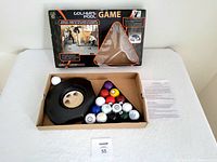 Lot contents including golf balls, pool rack, putting cups, instruction sheet, and damaged original box.