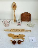 Full view of all kitchen lot items including vintage glassware and wooden kitchen decor displayed on a white surface.
