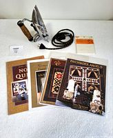 Vintage Singer iron with cork handle, fabric-covered cord showing minor fray, five quilting pattern booklets, and unopened Dritz iron-on muslin patches.