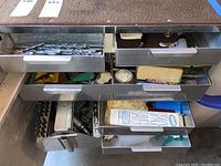 Top drawer with various sizes of twist drill bits and small accessories