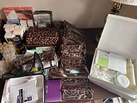 Wide view of multiple cosmetic and fragrance items arranged on table, including leopard-print cosmetic bags.