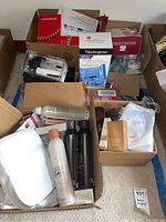 Multiple cardboard boxes containing beauty devices, hair care bottles, skincare and nail products