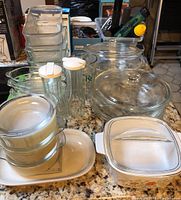 Photo of the entire collection showing various Pyrex and CorningWare glass baking dishes, glass salad dressing holders, and storage containers on granite countertop.