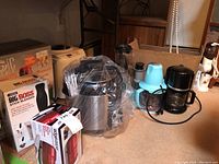 Wide view of multiple small kitchen appliances on carpeted floor