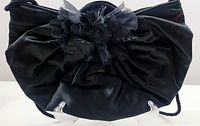 Front view of the black fabric evening handbag showing gathered fabric and flower detail