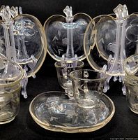 Photo showing the set of six clear glass apple-shaped snack plates, each with an etched floral and arrow pattern, along with matching etched glass cups.