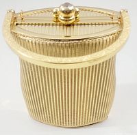 Front and top view of the vintage golden metal handbag showing ribbed texture and semi-circular handle with clasp closure