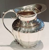 Full view of the vintage electroplated copper water pitcher with ice lip and ornate handle, showing reflective surface and shape.