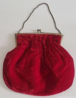 Front view of the vintage red velvet evening bag showing the velvet body and metal frame with clasp.