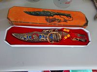 Decorative ornate dagger in detailed sheath placed inside original box with red cloth lining