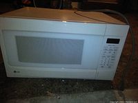 Exterior of white LG countertop microwave oven with keypad and display.