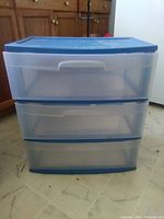 Two stacked Rubbermaid 3-drawer storage totes with blue lids and drawer fronts.