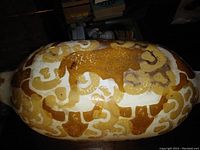 Top view of the oval ceramic crock showing the brownish-orange bull design on a cream background.