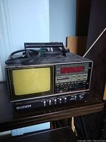 Front view showing CRT television screen, control panel, and cassette slot on device