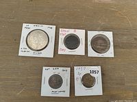 Photo showing five coins including the Mexican 25 Pesos silver coin, Spanish 1960 copy coin, 2013 US 25 cent Fort Henry coin, 1937 British 3 pence coin, and an unknown coin.