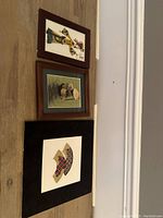 View of three framed Asian embroidery artworks laid on floor, showing overall condition and size differences