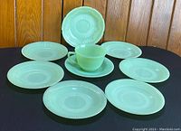 Photos show the full set of 1 cup and 8 saucers on a black backdrop with a wood paneled background to highlight colors and condition.